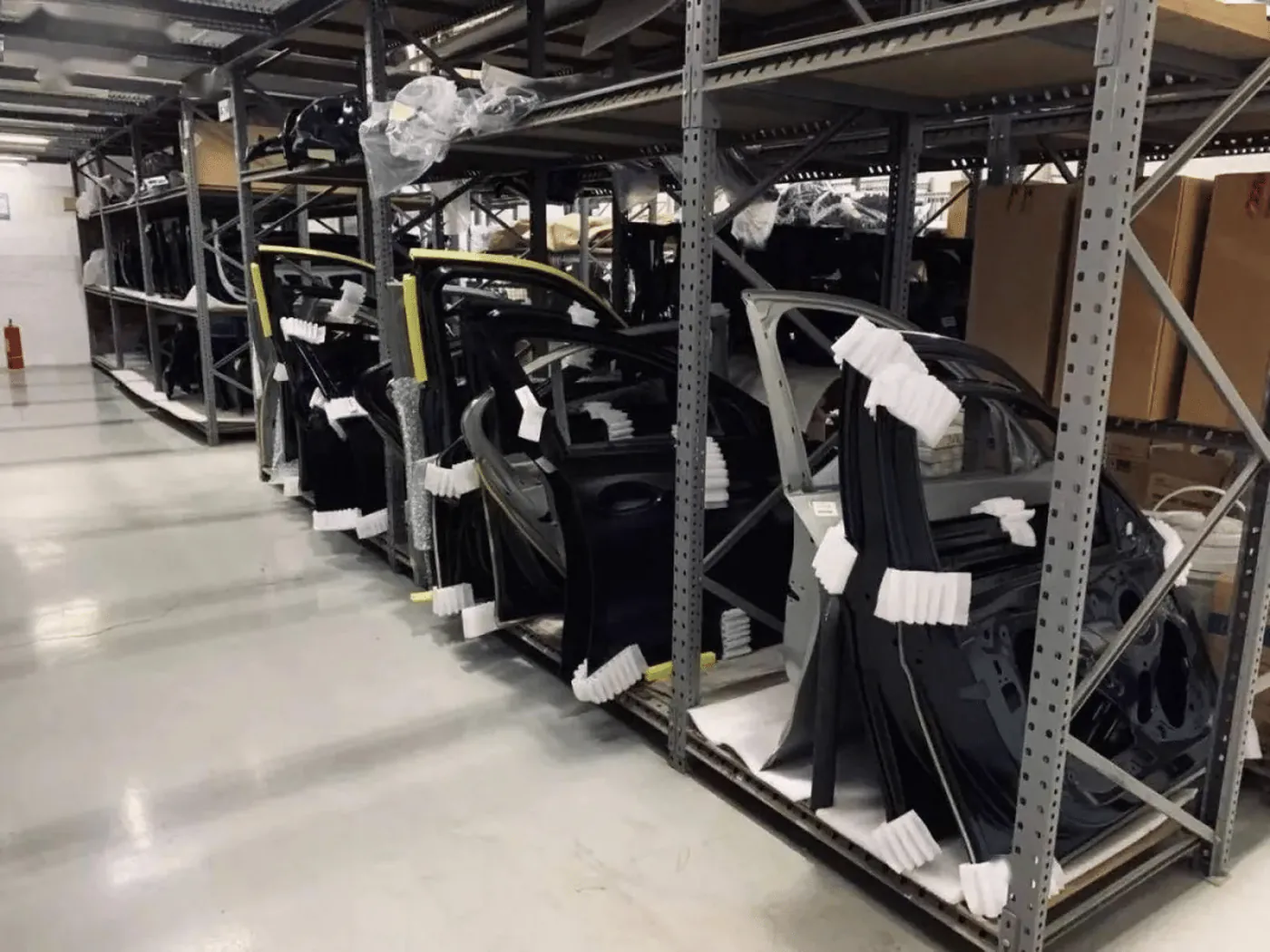 Long warehouse aisle with parts bins stretching into the distance